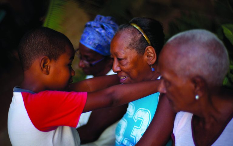 In this picture taken Aug 1, 2012, a child visits with his grandmother at a senior center, that provides retirees with medical attention, meals and social activities, in Havana, Cuba. Cuba grapples with having the oldest citizenry in Latin America, a phenomenon fueled by low birth rates and long life expectancies, plus the migration of young people and women. The government has already postponed the retirement age and is trying to create more homes and programs for the elderly, but still will have to handle the economic consequences of its increasingly graying population.(AP Photo/Ramon Espinosa)