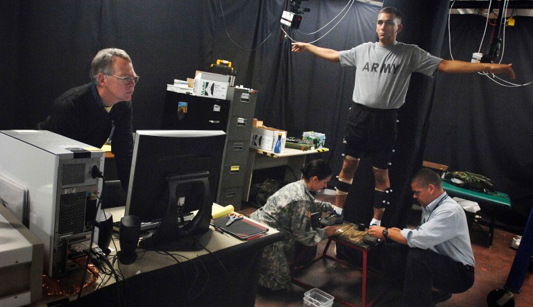 Sgt. Michael Cavallo, a research assistant at the U.S. Army Research Institute of Environmental Medicine, Natick, Mass., is fitted May 6, 2009, with sensors that will be detected by infrared cameras as he walks on a patented, force-sensing treadmill invented by those at the lab. The sensors capture his movements and translate it to data and the treadmill measures the force placed on his body while shouldering a load.