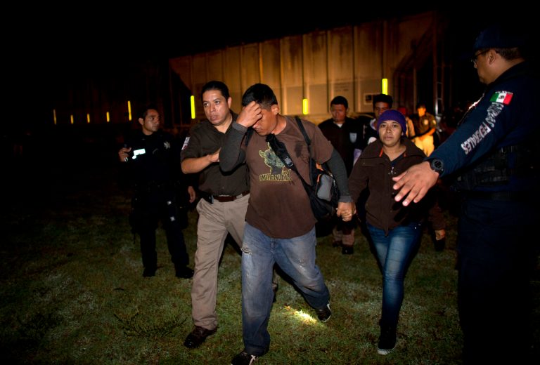 Immigration officials detain Central American migrants during a raid by federal police on a northbound freight train, in San Ramon, Mexico, just after midnight on Friday, Aug. 29, 2014. (AP Photo/Rebecca Blackwell)