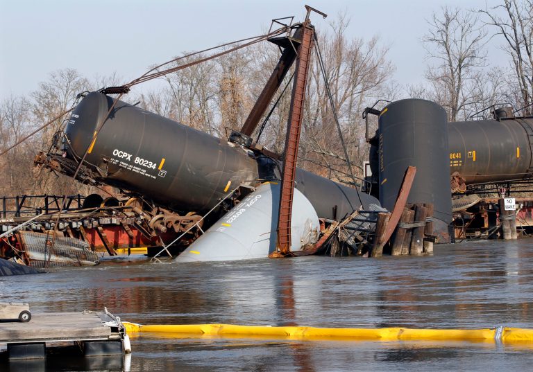   A containment boom floats in Mantua Creek Saturday, Dec. 1, 2012, near freight train tank cars that derailed Friday in Paulsboro, N.J. Residents in an area of about 12 blocks near the derailment remain out of their homes as officials continued their efforts to clear a hazardous gas that spewed from a ruptured freight train car. The precautionary evacuations were ordered late Friday, hours after a train derailment, and will likely remain in effect throughout the weekend and possibly longer. The order came after readings showed higher levels of vinyl chloride in the air. (AP Photo/Mel Evans)  