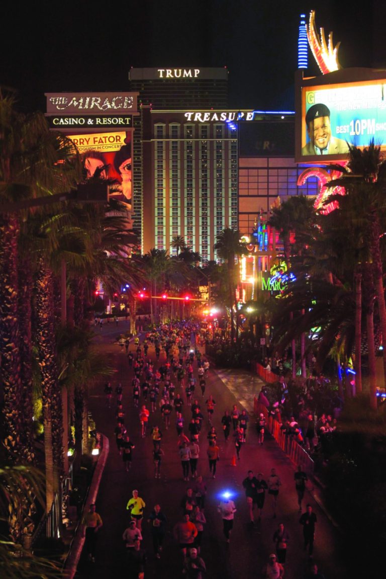 FILE - In this file photo taken Sunday, Dec. 4, 2011, runners stream southward on Las Vegas Boulevard during the Rock 'n Roll Las Vegas Marathon. After health officials investigated a stomach illness following last year's marathon and Half-Marathon, organizers are promising several changes to this year's races _ including strict sanitation rules and a contractor supplying water to runners. (AP Photo/Julie Jacobson, File)