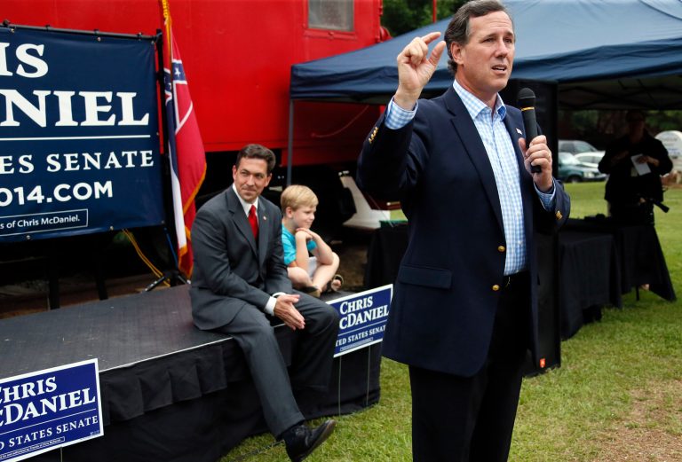 Former Republican presidential candidate Rick Santorum, right, endorses state Sen. Chris McDaniel, seated with son Cambridge, 7, at a rally in Madison, Miss., Thursday, June 19, 2014. McDaniel is in a runoff against long-time U.S. Sen. Thad Cochran for the GOP nomination for Cochran's seat. Santorum's appearance is one of several 