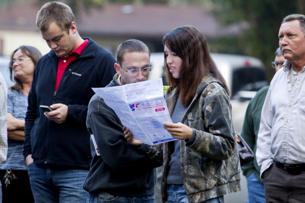 CRAWFORDVILLE, FL -  NOVEMBER 6:  Robert Ceska (L) and Meagan Lewis look over a sample ballot just after dawn as people line up to vote at the County Polling House on November 6, 2012 in Crawfordville, Florida. The swing state of Florida is a hotly contested battleground that offers 29 electoral votes. Recent polls show that the race between U.S. President Barack Obama and Republican presidential candidate Mitt Romney remains tight. (Photo by Mark Wallheiser/Getty Images)