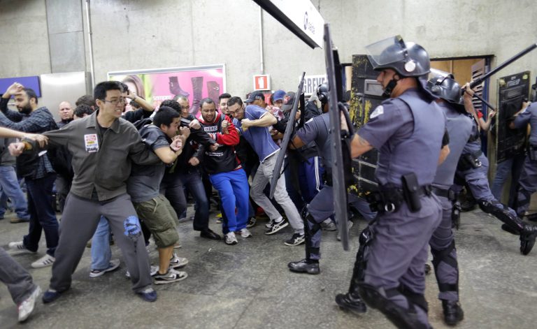 Subway train operators, along with some activists, clash with police at the Ana Rosa metro station on the second day of their metro strike in Sao Paulo, Brazil, Friday, June 6, 2014. The workers clashed with police as they tried to block other operators from breaking the strike. Overland commuter train operators went on strike Thursday, putting at risk the only means that most soccer fans will have to reach Itaquerao stadium ahead of next week's World Cup. (AP Photo/Nelson Antoine)
