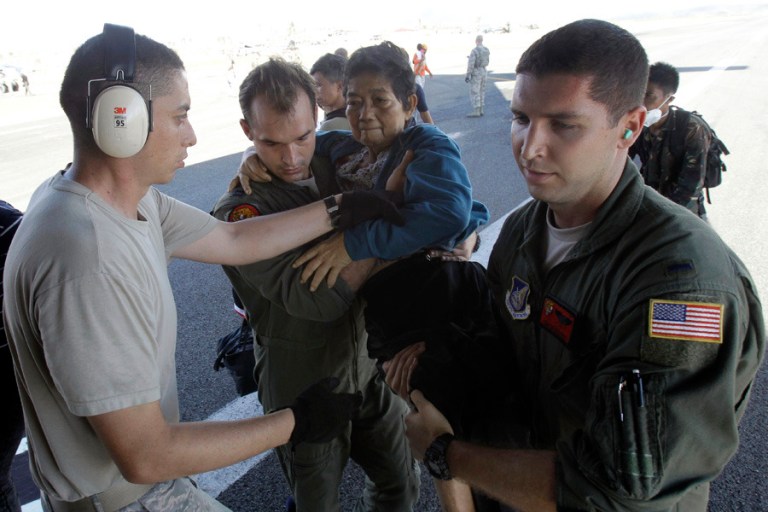 US Air Force 535th Airlift Squadron crew aid a handicapped typhoon victim into a tightly packed C-17 aircraft for an evacuation at the airport in Tacloban, Philippines, Monday, Nov. 18, 2013.

Wally Santana/AP
