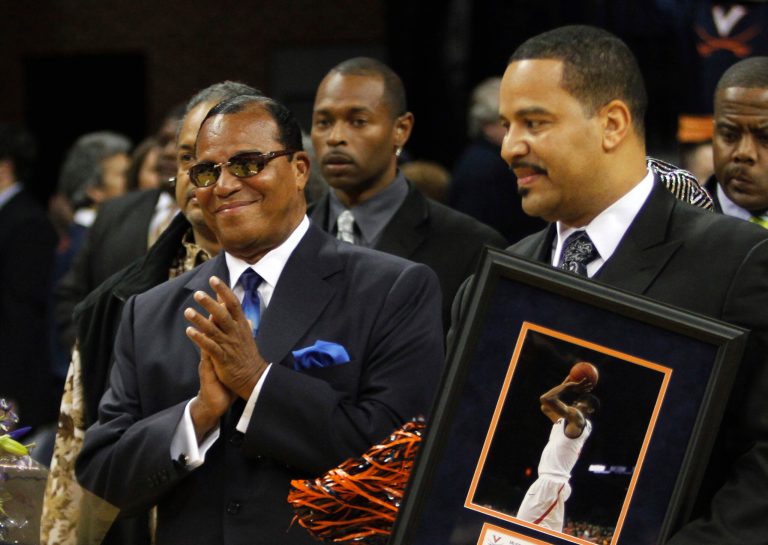FILE - In this March 2, 2011, Nation of Islam Minister Louis Farrakhan, left, and his son Mustapha Farrakhan, are seen during ceremonies honoring Virginia seniors, including Mustapha's son, at an NCAA college basketball game in Charlottesville, Va. A state law enforcement agency is investigating Mustapha Farrakhan after a newspaper determined he is a part-time suburban police officer who uses an unmarked squad car to provide traffic control for his father, an official said Monday April 22, 2013. (AP Photo/Steve Helber, File)