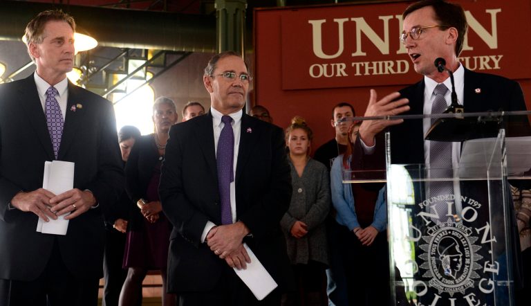 Union College President Stephen C. Ainlay, right, speaks in the Nott Memorial with State Lt. Governor Robert J. Duffy, left, and District Attorney Robert Carney as they recognize the Union College national championship hockey team's effort to raise awareness to stop sexual assault and domestic violence Tuesday, Oct. 7, 2014 in Schenectady, N.Y. Players signed the so-called 