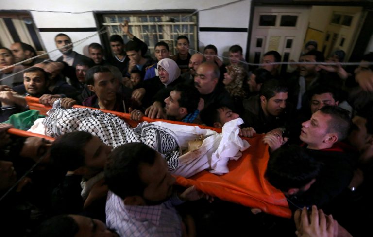 Mourners carry the body of Bilal Aweida, a 20-year-old Palestinian man, during his funeral in Beit Lahiya, northern Gaza Strip, Friday, Jan. 24, 2014 . Health Ministry spokesman Ashraf al-Kidra in Gaza said Aweida, 20, was shot dead during clashes with Israeli soldiers in east Gaza City. (AP Photo/Hatem Moussa)