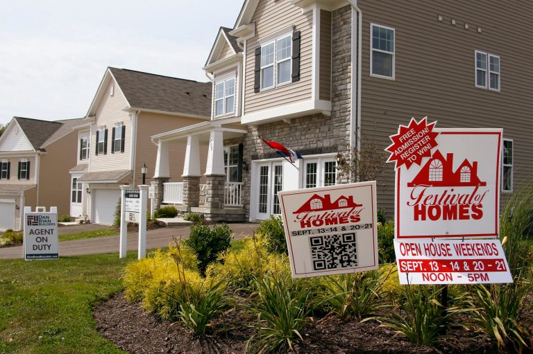 In this photo made on Wednesday, Sept. 10, 2014, signs welcome visitors to a model home as construction is under way at a housing development in Zelienople, Pa. Average long-term U.S. mortgage rates rose slightly this week but remained near their lows for the year. (AP Photo/Keith Srakocic)