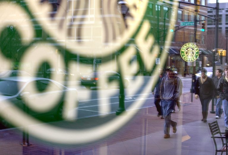   FILE - In this Wednesday, Jan. 26, 2011, file photo, pedestrians are reflected outside a Starbucks store in Atlanta. Starbucks, the world's biggest coffee company, is planning to add at least 1,500 cafes in the U.S. over the next five years. The plan, which would boost the number of Starbucks cafes in the country by about 13 percent, was announced at the company's investor day in New York,Wednesday. Taking into account Canada and South America, the company plans to add a total of 3,000 new cafes in its broader Americas region. (AP Photo/David Goldman, File)  