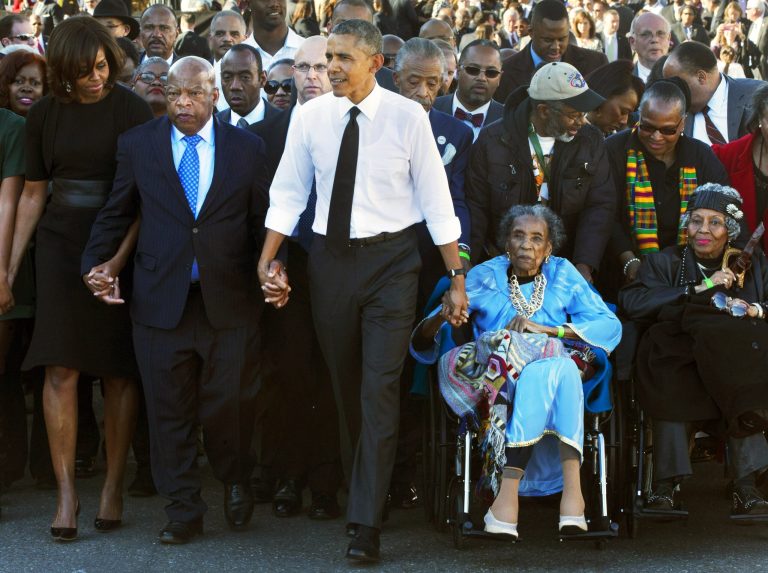 In this March 7, 2015Â photo,Â President Barack Obama, center, holds hands with Rep. John Lewis, D-Ga., left, and Amelia Boynton Robinson, right, who were both beaten during 