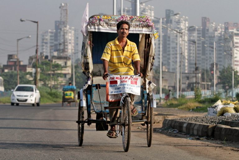 Satyen Das rides his rickshaw on a road in Kolkata, India, Thursday, Oct. 9, 2014. It took 68 days for Das to laboriously pedal his rickety, self-remodeled bicycle rickshaw from the seaside Indian city of Kolkata to the roof of the world - a 5,369-meter (17,600-foot) Himalayan peak. His goal: to promote his chassis as an environmentally sound travel option. (AP Photo/Bikas Das)