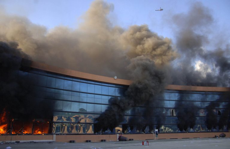A police helicopter flies overhead as the Guerrero state capital building burns after it was set on fire by protesting college students in Chilpancingo, Mexico, Monday Oct. 13, 2014. Hundreds of protesting teachers and students demanding answers about the 43 students who went missing on Sept. 26 during a confrontation with police, clashed with police at the local congress and outside the state government palace Monday. Officials are attempting to determine if any of the missing students are in newly discovered mass graves. (AP Photo/Alejandrino Gonzalez)