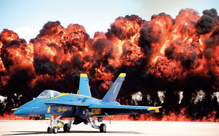 The flight line behind U. S. Navy Captain Greg McWherter's Blue Angels jet erupts in flames during a pyrotechnics display in a simulated attack by an A-10 Thunderbolt during the Guardians of Freedom Airshow at the Lincoln Air Park. (AP/FRANCIS GARDLER / Lincoln Journa, Lincoln Journal Star)