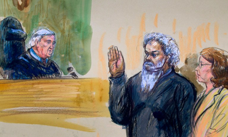 This June 28, 2014, artist's rendering shows United States Magistrate, Judge John Facciola, swearing in the defendant, Libyan militant Ahmed Abu Khatallah, wearing a headphone, as his attorney Michelle Peterson watches during a hearing at the federal U.S. District Court in Washington. The Libyan militant now in U.S. custody in the Benghazi attacks was motivated to do so by his extremist ideology, the government said Tuesday, July 1. In the days before the attacks, Ahmed Abu Khattala voiced concern and opposition to the presence of an American facility in Benghazi, according to a federal court filing. (AP Photo/Dana Verkouteren)