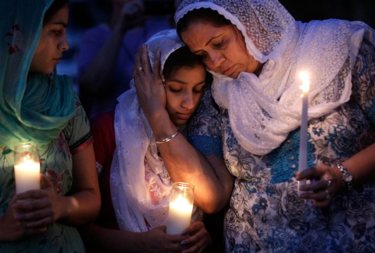   FOR USE AS DESIRED WITH SIKH TEMPLE SHOOTING ANNIVERSARY STORIES - FILE - In this Aug. 6, 2012, file photo worshipers from the Sikh community gather for a candle light vigil after prayer services in Brookfield, Wis. Twelve months ago, a white supremacist walked into a the temple and opened fire on worshippers he didn't know, killing six and devastating a Sikh community whose religion is based on peace and forgiveness. Monday is the one-year anniversary of the shooting. (AP Photo/M. Spencer Green, File)  