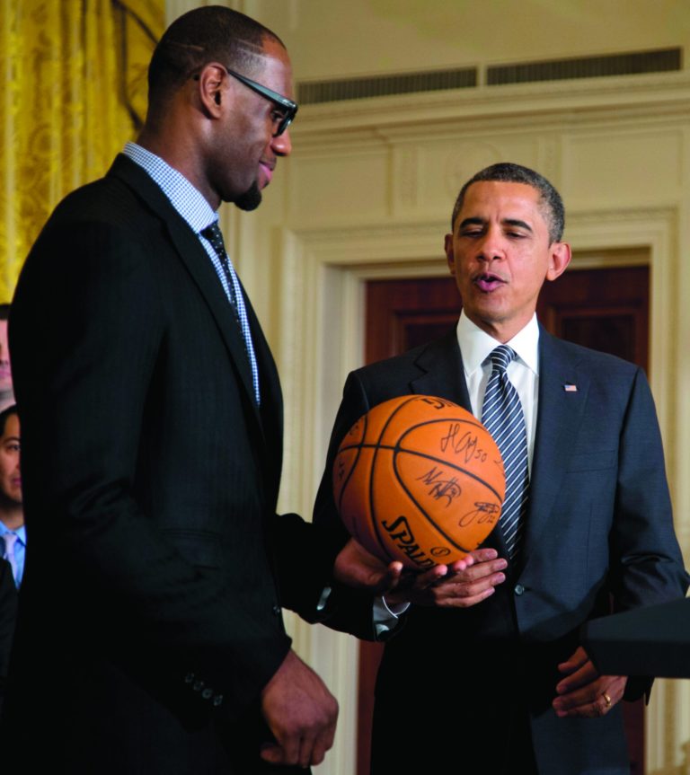 President Barack Obama accepts a signed basketball from Miami Heat forward LeBron James as he welcomes the the NBA basketball champion Miami Heat, to the East Room of the White House, Monday, Jan. 28, 2013, in Washington. (AP Photo/Carolyn Kaster)