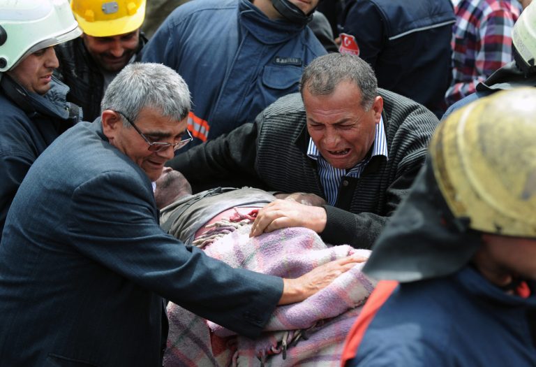 A man cries over the body of a miner being carried outside the coal mine in Soma, Turkey, Wednesday, May 14, 2014. Rescuers desperately raced against time to reach more than 200 miners still trapped underground Wednesday after an explosion and fire at the coal mine on Tuesday killed at least 238 workers. (AP Photo/Depo Photos)