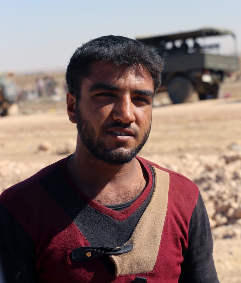 Dalil Boras, a 19-year-old Kurdish militant who has been fighting the Islamic State group in Syria, speaks to the Associated Press in Suruc, Turkey, Sunday, Sept. 21, 2014. Dalil brought his family over the border to Turkey to safety Sunday. But in the tranquility of a Turkish tea garden a few miles from the border, he vowed to head back to the fight Sunday night. (AP Photo/Burhan Ozbilici)