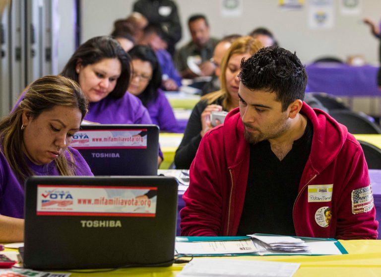 Labor union workers assist people during a health care enrollment event at the SEIU-UHW office in Commerce, Calif., on March 31. (AP Photo/Ringo H.W. Chiu)