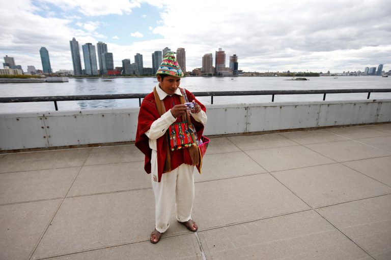 Tomas Mamani, of La Paz, Bolivia, looks at his camera after taking a photo outside United Nations headquarters, Monday, Sept. 22, 2014.  The World Conference on Indigenous Peoples began Monday at the U.N. (AP Photo/Jason DeCrow)