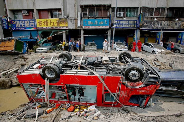 A destroyed fire truck is seen overturned in the rubble after massive gas explosions in Kaohsiung, Taiwan, Friday, Aug. 1, 2014. A series of underground explosions about midnight Thursday and early Friday ripped through Taiwan's second-largest city, killing scores of people, Taiwan's National Fire Agency said Friday. (AP Photo/Wally Santana)
