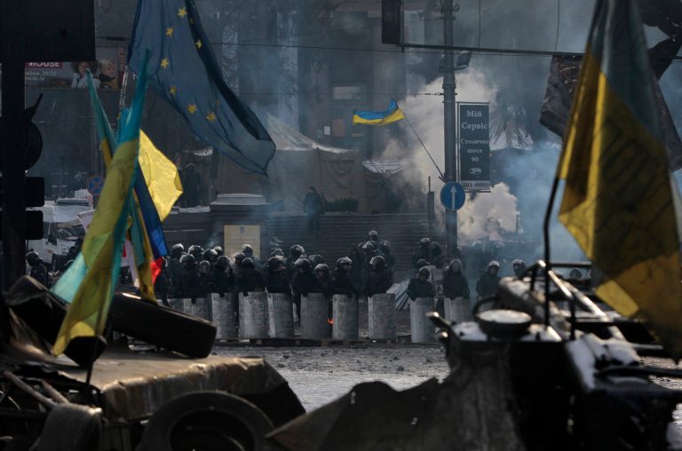 Riot police line up as seen through protesters' barricades in central Kiev, Ukraine, Saturday, Feb. 1, 2014. Ukraine's embattled president Viktor Yanukovych is taking sick leave as the country's political crisis continues without signs of resolution. (AP Photo/Sergei Chuzavkov)