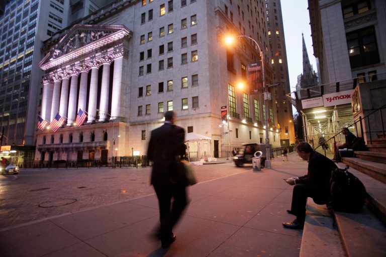 In this Oct. 8, 2014 photo, a man walks to work on Wall Street, near the New York Stock Exchange, in New York. Stocks are opening higher Tuesday, Oct. 21, 2014 after several big companies reported results that pleased investors. (AP Photo/Mark Lennihan)
