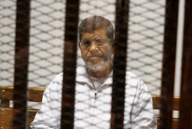 Egypt's ousted Islamist President Mohammed Morsi sits in a defendant cage in the Police Academy courthouse in Cairo, Egypt. On Tuesday April 21, 2015, an Egyptian criminal court sentenced Morsi to 20 years in prison over the killing of protesters in 2012, the first verdict to be issued against the leader. The case stems from violence outside the presidential palace in December 2012. (AP Photo/Tarek el-Gabbas, File)
