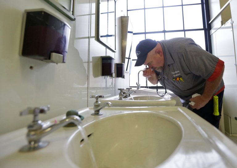 Al Jones of the West Virginia department of General Services tests the water on the first floor of the State Capitol in Charleston, W.Va., on Jan. 13. (AP Photo/Steve Helber)