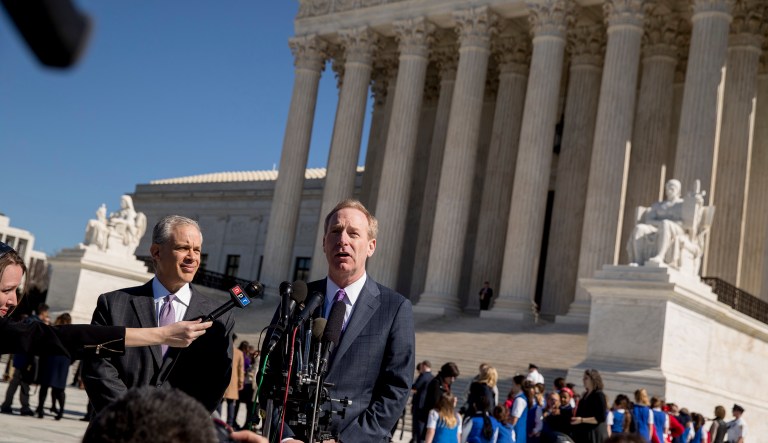 Microsoft President and Chief Legal Officer Brad Smith, accompanied by Attorney Josh Rosenkranz, left, speaks to reporters outside the Supreme Court in Washington. The Supreme Court heard arguments Tuesday in a dispute between the Trump administration and Microsoft Corp. over a warrant for emails that were sought as part of a drug trafficking investigation.