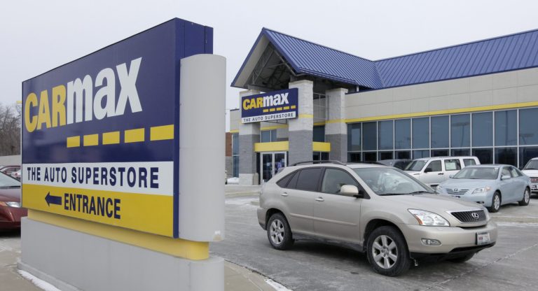 FILE - In this file photo taken Monday, Dec. 20, 2010, a car drives past the CarMax sign at the dealership in Oak Lawn, Ill. CarMax on Monday, April 28, 2014 said it is ending its sponsorship of the NBA's Los Angeles Clippers in the wake of racist comments attributed to team owner Donald Sterling. (AP Photo/M Spencer Green, File)