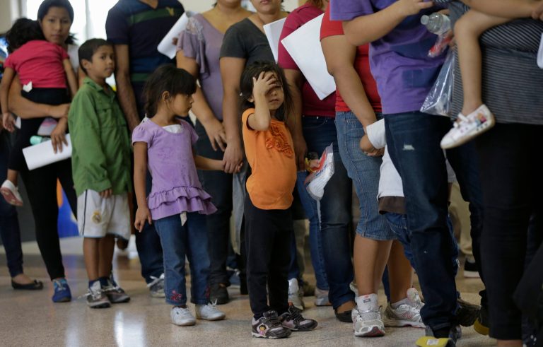 In this June 20, 2014, file photo, immigrants who entered illegally stand in line for bus tickets after they were released from a U.S. Border facility. Homeland Security is planning a series of raids targeted at hundreds of people who have managed to escape deportation. (AP Photo/Eric Gay)