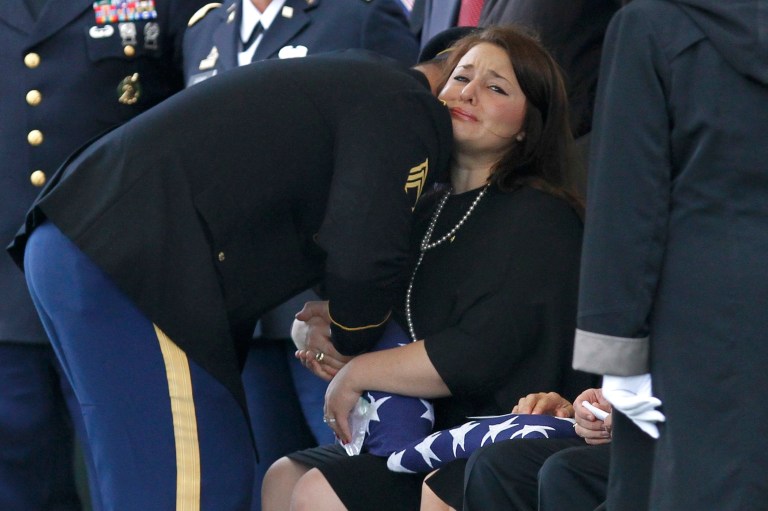 Oklahoma National Guard Staff Sgt. Kenny Butler comforts Jane Horton, widow of U.S. Army Spc. Christopher D. Horton, 26, of Collinsville, Okla., who died while serving in Afghanistan, Wednesday, Oct. 12, 2011, during the burial services at Arlington National Cemetery in Arlington, Va. (AP Photo/Jacquelyn Martin)