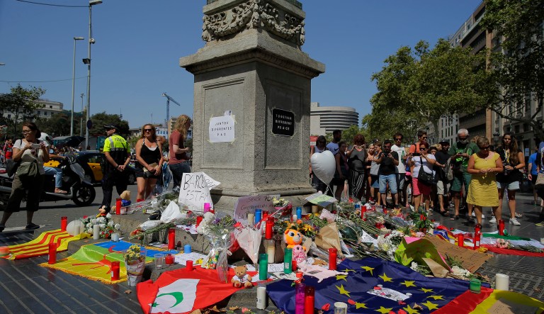 People look at flags, messages and candles placed after van attack that killed at least 13, in central Barcelona, Spain. An American citizen died in the terrorist attack, Secretary of State Rex Tillerson announced Friday. (AP Photo/Manu Fernandez)