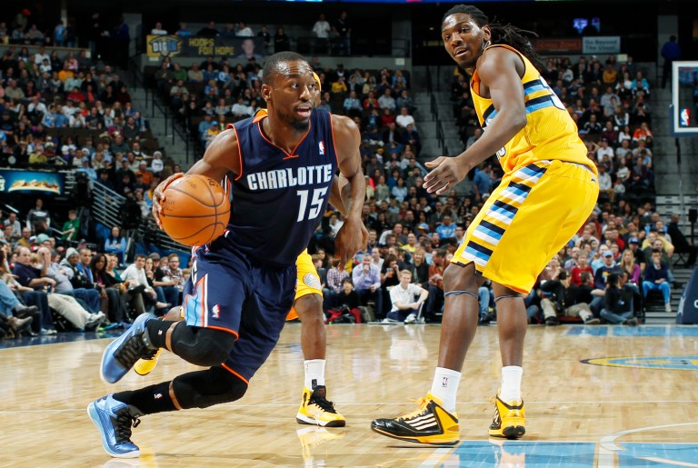   Charlotte Bobcats guard Kemba Walker, front left, slips past Denver Nuggets guard Ty Lawson, back left, and forward Keneth Faried for a shot in the first quarter of an NBA basketball game in Denver, Saturday, Dec. 22, 2012. (AP Photo/David Zalubowski)  