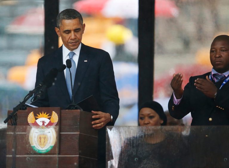 President Barack Obama looks down as he stands next to the sign language interpreter as he makes his speech at the memorial service for former South African president Nelson Mandela at the FNB Stadium in Soweto near Johannesburg, Tuesday, Dec. 10, 2013. South Africa's deaf federation said on Wednesday that the interpreter on stage for Mandela memorial was a 'fake', (AP Photo/Matt Dunham)