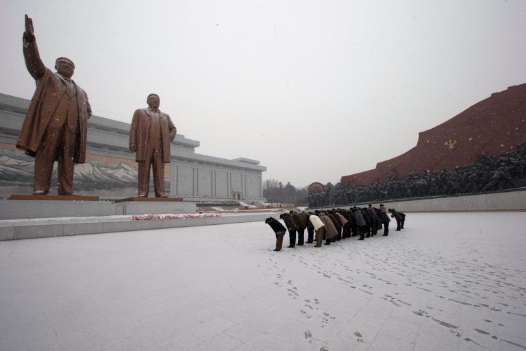   North Koreans bow in front of the statues of late North Korean leaders Kim Il Sung, left, and Kim Jong Il at Mansu Hill as it snows in Pyongyang, North Korea, Friday, Dec. 21, 2012. (AP Photo/Ng Han Guan)  