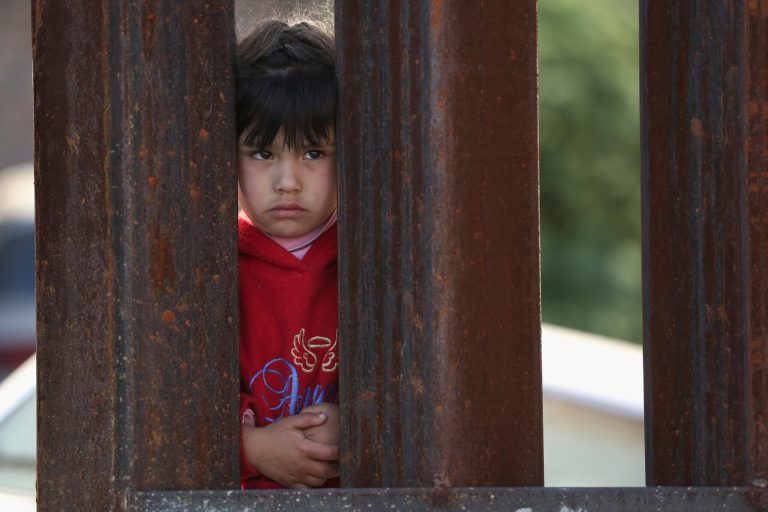 A child on the Mexican side of the U.S.-Mexico border fence looks into Arizona during a special 'Mass on the Border' on April 1, 2014 in Nogales, Ariz. (Photo by John Moore/Getty Images)