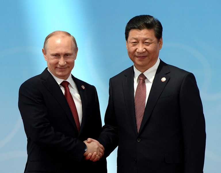Russian President Vladimir Putin, left, shakes hands with Chinese President Xi Jinping before the opening ceremony at the Expo Center at the fourth Conference on Interaction and Confidence Building Measures in Asia (CICA) summit in Shanghai Wednesday, May 21, 2014.  China's president has called for creation of a new Asian structure for security cooperation based on a regional group that includes Russia and Iran and excludes the United States.  (AP Photo/Mark Ralston, Pool)