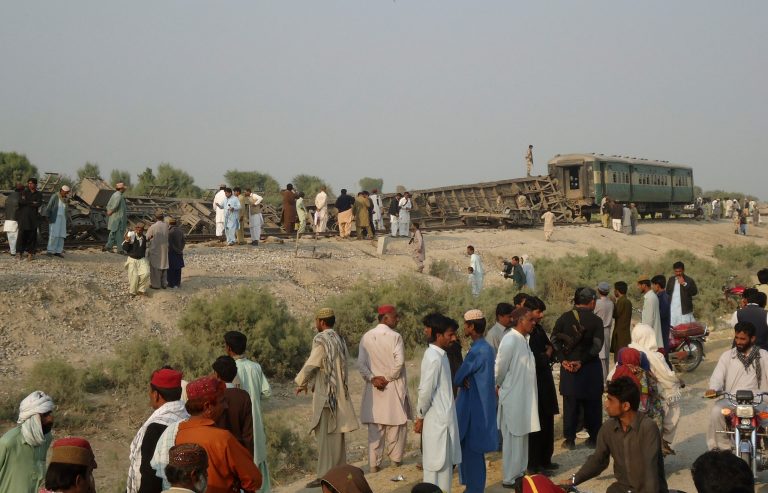 Pakistanis gather at the site of a deadly bomb blast that hit a train, in Kashmor district, Pakistan, Sunday, Feb. 16, 2014. A bomb placed by an ethnic separatist group derailed a train in southwest Pakistan on Sunday, killing several people including children, and wounding tens more police and the militants said. (AP Photo/Fida Hussain)