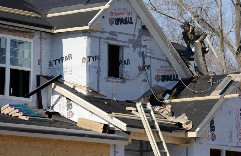 A builder works on the the roof of a new home under construction on Friday, Dec. 27, 2013., in Wilmette, Ill. (AP Photo/Nam Y. Huh)
