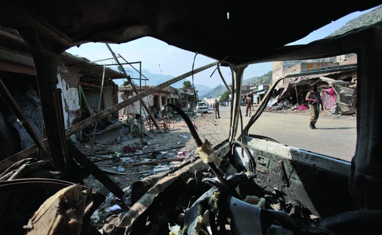 Seen through the wreckage of a vehicle, Pakistani Army soldiers check the site of a car bomb explosion in the Pakistani town of Darra Adam Khel in the troubled Khyber Pakhtunkhwa province bordering Afghanistan, Saturday, Oct. 13, 2012. A powerful car bomb went off outside the offices of pro-government tribal elders in northwestern Pakistan on Saturday, killing several people, police said. (AP Photo/Mohammad Sajjad)