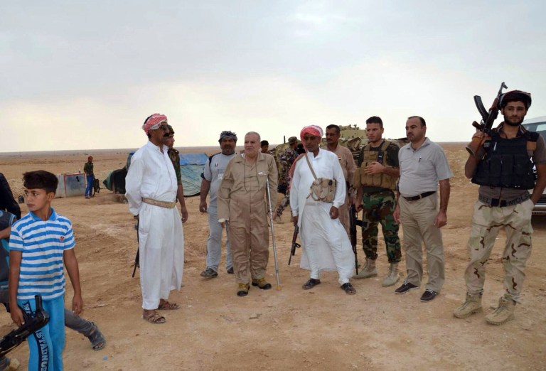 In this Friday, Oct. 17, 2014 photo, Iraqi security forces and tribal fighters gather to defend the city of Haditha, 240 kilometers (150 miles) northwest of Baghdad, Iraq. Iraq is facing its worst crisis since the 2011 withdrawal of U.S. troops, with the Islamic State extremist group in control of about a third of the country. (AP Photo)