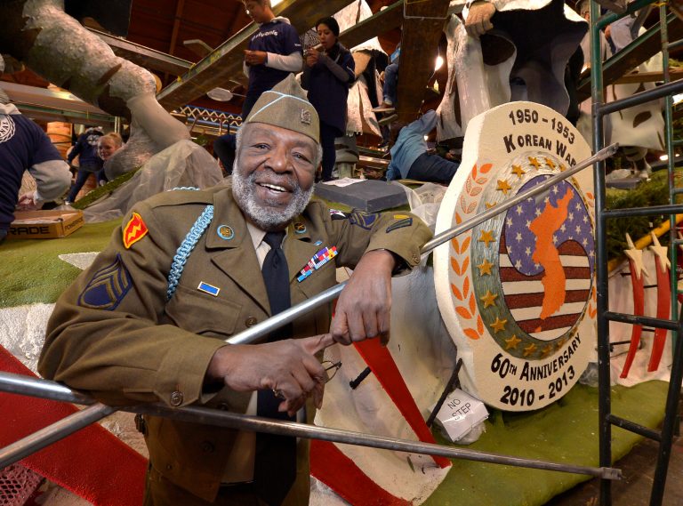   Korean War veteran James McEachin, 82, poses in front of the Rose Parade float âFreedom Is Not Freeâ by the Korean War Commemoration Committee, Saturday, Dec. 29, 2012, in Pasadena, Calif. McEachin is scheduled to ride the float in the Rose Parade on Tuesday, Jan. 1, 2013. (AP Photo/Mark J. Terrill)  