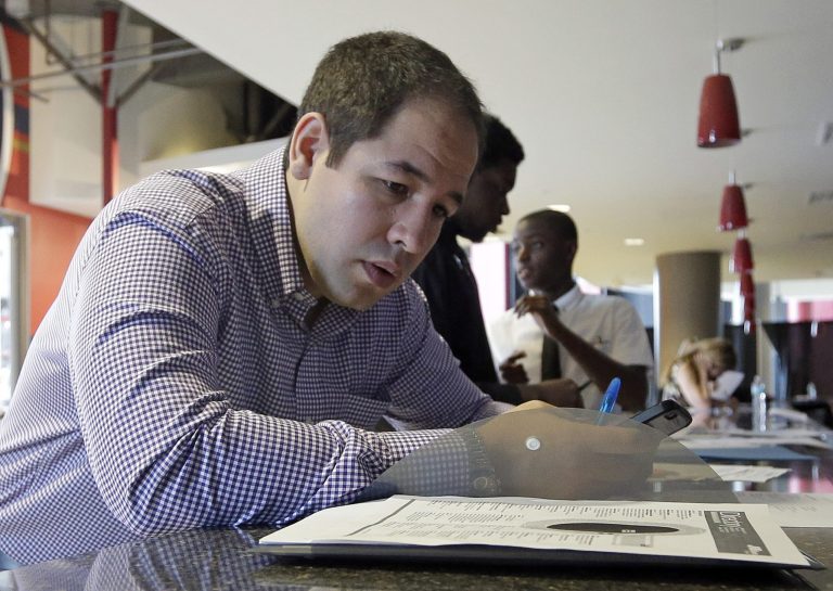 In this photo taken June 10, 2015, Luis Duran fills out a job application during a job fair in Sunrise, Fla. (AP Photo/Alan Diaz)