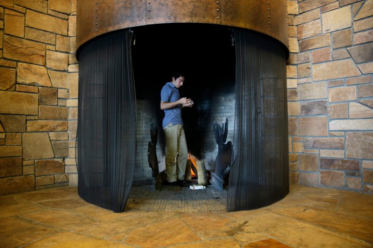 Mertcan Kara lights a fire at the Jackson Lake Lodge in Grand Teton National Park near Jackson, Wyo. Saturday, Aug. 23, 2014. The Federal Reserve Bank of Kansas City is holding the Jackson Hole Economic Policy Symposium at the hotel. (AP Photo/John Locher)
