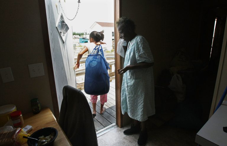 Courtney Barthelemy, 18, carries out laundry as grandmother Ethel Manuel looks from her FEMA Diamond travel trailer park trailer May 23, 2008 in Port Sulphur, Louisiana. (Photo by Mario Tama/Getty Images)