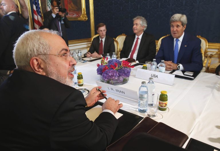 FILE - In this Monday, July 14, 2014 file photo, Iran's Foreign Minister Mohammad Javad Zarif, foreground left, holds a bilateral meeting with U.S. Secretary of State John Kerry, background right, on the second day of talks, in Vienna, Austria. With differences still unresolved and a Nov. 24 deadline for a deal nearing, Iran and the United States have a choice to make: Extend nuclear talks for the second time or face the risk of renewed confrontation and armed conflict. (AP Photo/Jim Bourg, Pool-File)