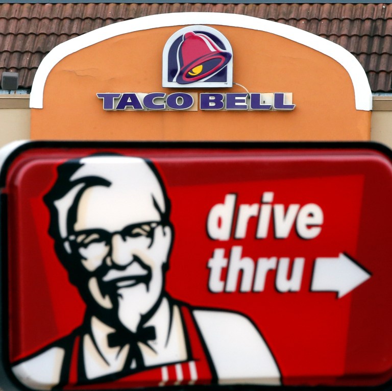 This Jan. 31, 2014 photo shows a Taco Bell facade behind a KFC drive-thru sign in Saugus, Mass. Fast-food conglomerate Yum! Brands, Inc., headquartered in Louisville, Ky., reports quarterly earnings on Tuesday, April 22, 2014. (AP Photo/Elise Amendola)